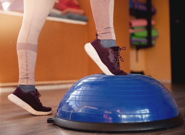 close-up woman's feet stepping onto BOSU ball