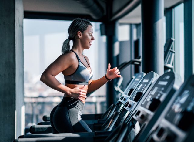 woman doing sprints on treadmill at gym, belly fat exercises concept