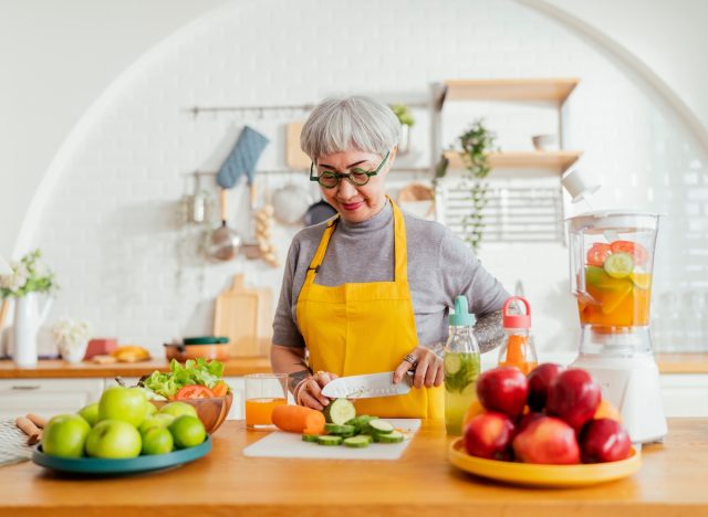 woman chopping veggies in bright kitchen