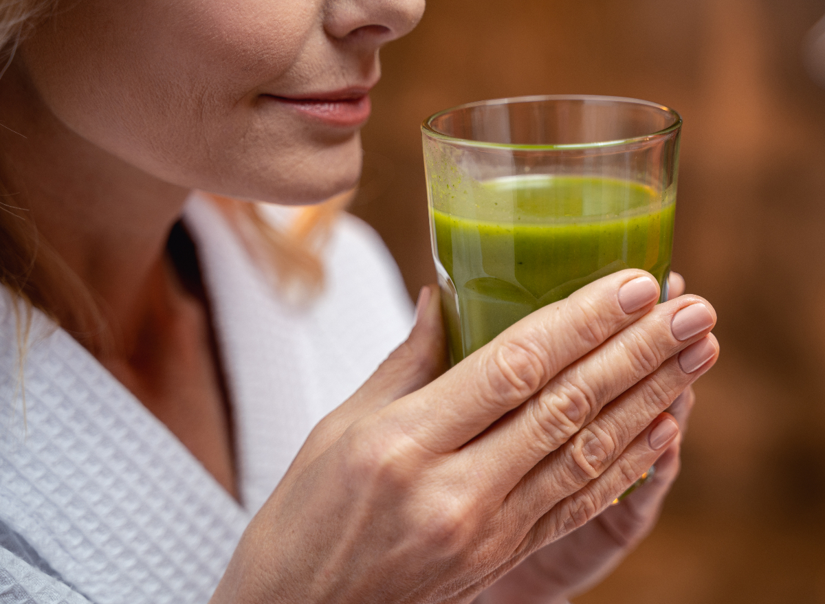 woman close-up drinking green juice, concept of mistakes women make that slow their metabolism