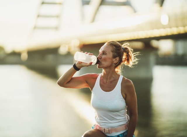 woman resting, drinking water taking a break from workout