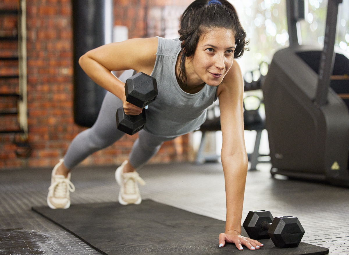 woman doing dumbbell plank rows, concept of exercises to slim down for good