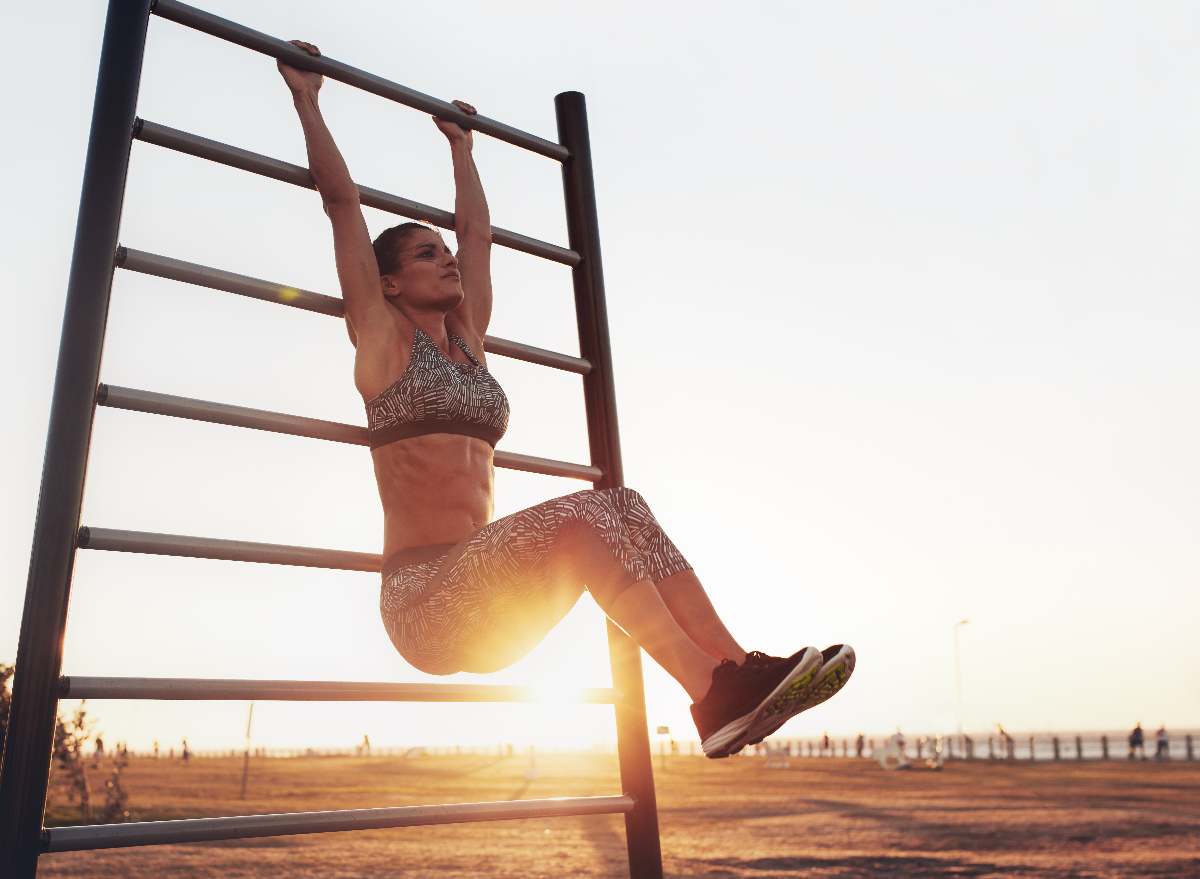 fit woman doing hanging knee raises, concept of strength exercises for women to get instant abs