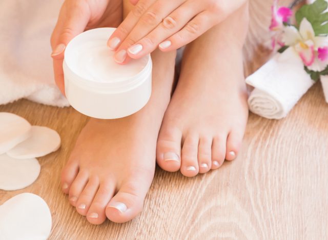woman putting lotion on her feet