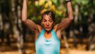 muscular woman doing pull-ups outdoors, concept of exercises to melt hanging belly fat in your 40s
