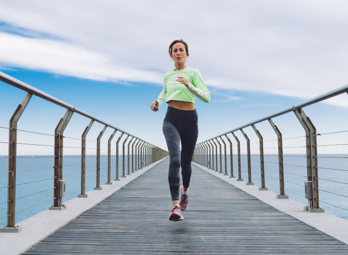 woman sprinting, running down pier, concept of bad fitness habits that destroy your body after 30