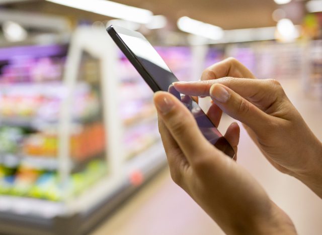 woman using mobile phone at supermarket