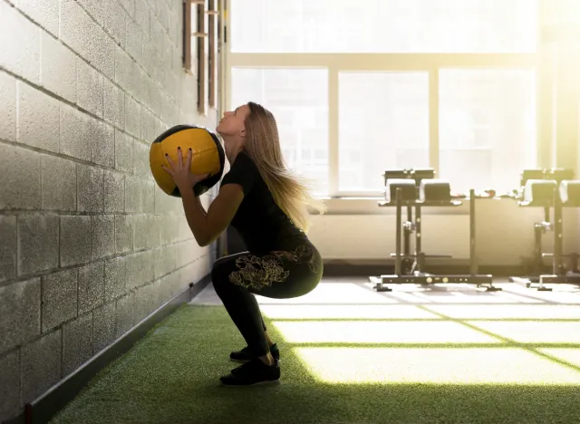 woman does wall ball exercises