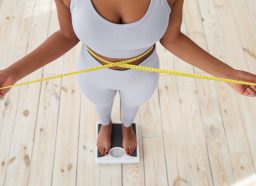 woman measuring waistline, on scale, concept of tips to lose 10 pounds in one month
