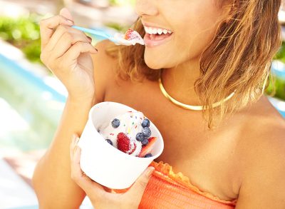 Happy young woman enjoying frozen yogurt