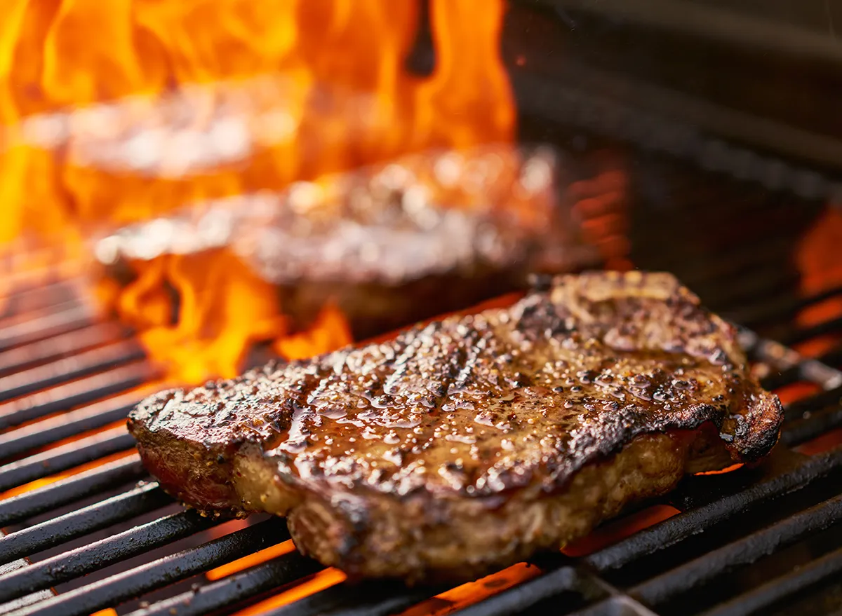 grilling new york strip steaks over flames