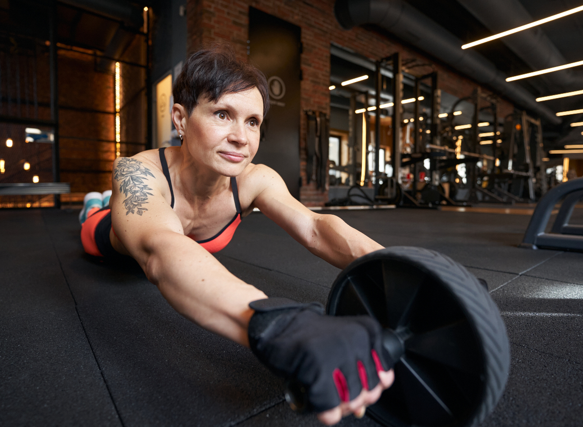 woman doing ab wheel rollout belly fat exercises