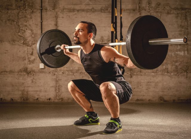 middle-aged man doing barbell back squats