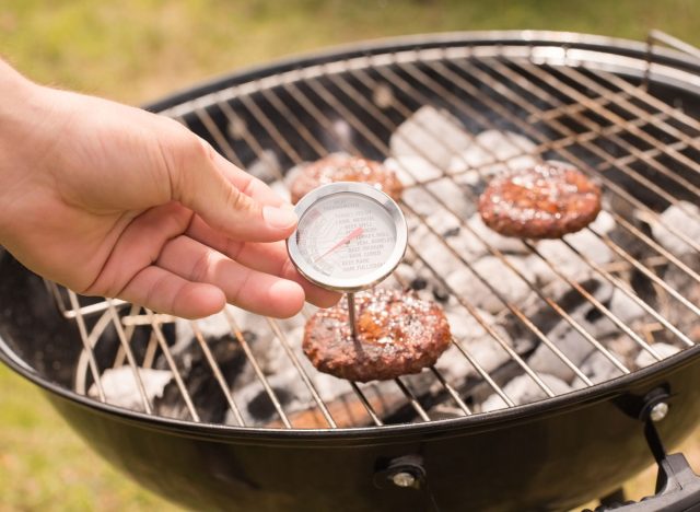 meat thermometer in burger on grill