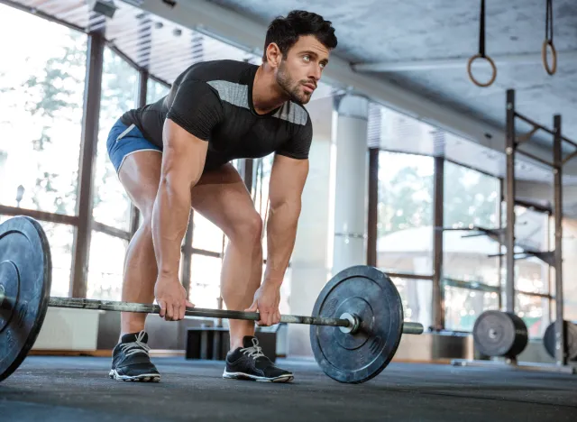 man doing barbell deadlifts exercise, concept of daily free weight exercises for men to stay fit
