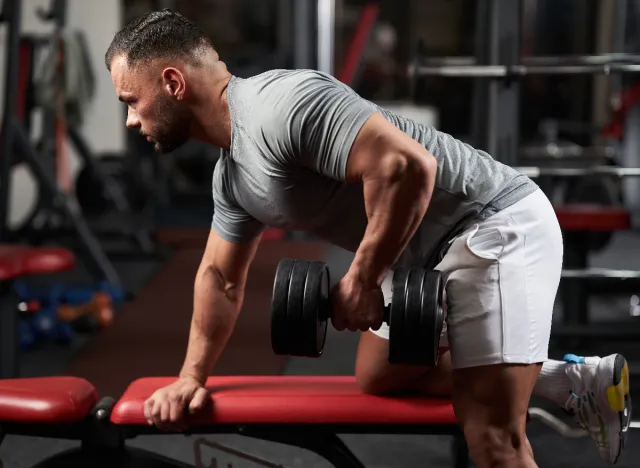 muscular man doing dumbbell rows