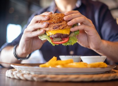 man eating cheeseburger