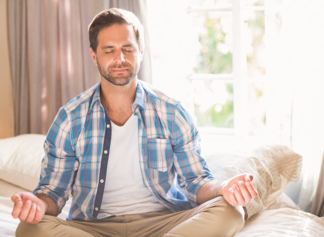 man meditating in bed