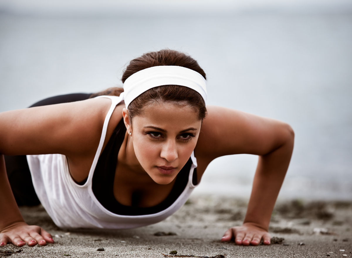 https://www.eatthis.com/wp-content/uploads/sites/4/2023/06/woman-doing-pushups-1.jpg?quality=82&strip=1