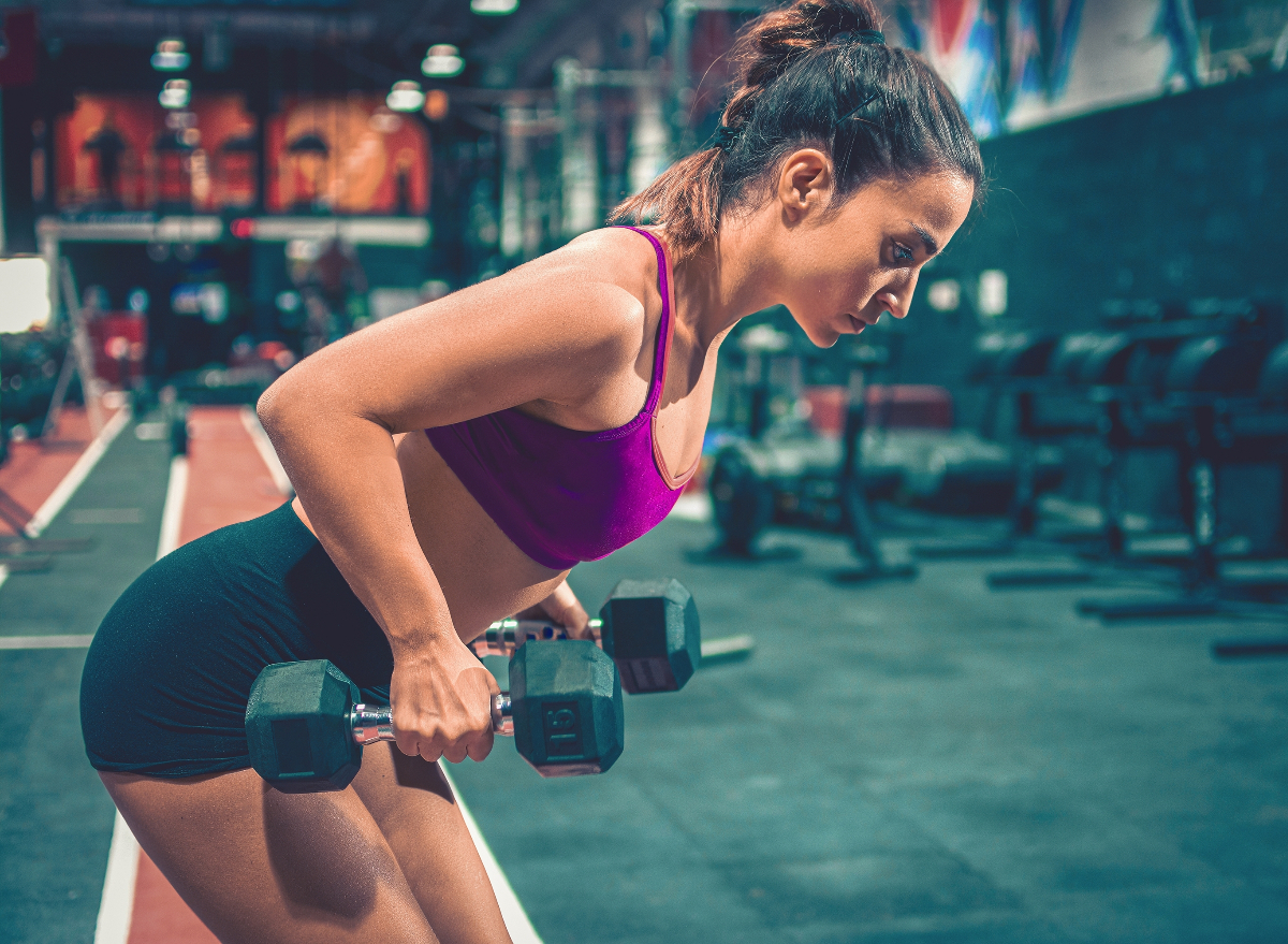 woman doing dumbbell rows, concept of exercises to lose 10 pounds