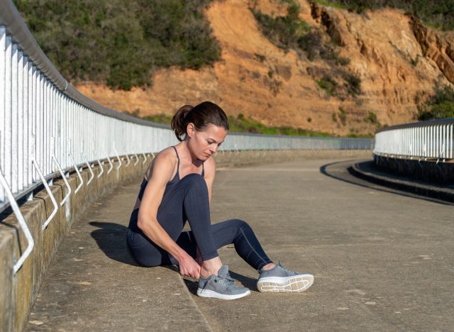 fitness woman putting on running sneakers