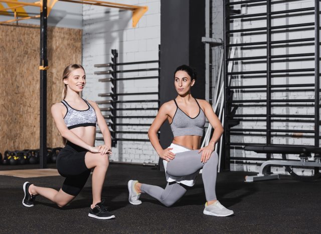 two fit women doing walking lunges