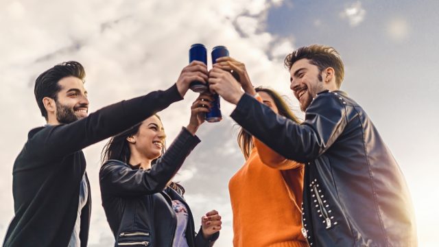 Adults holding canned energy drinks