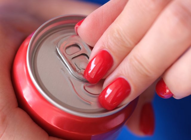 close-up woman's hands opening soda can