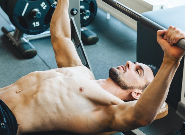 fit man doing barbell bench press, concept of exercises for men to improve strength