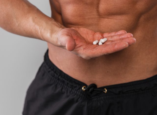 close-up man holding supplements