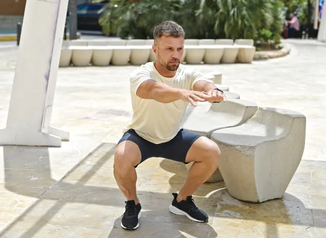 fit man doing squats, concept of challenging workouts to increase gains