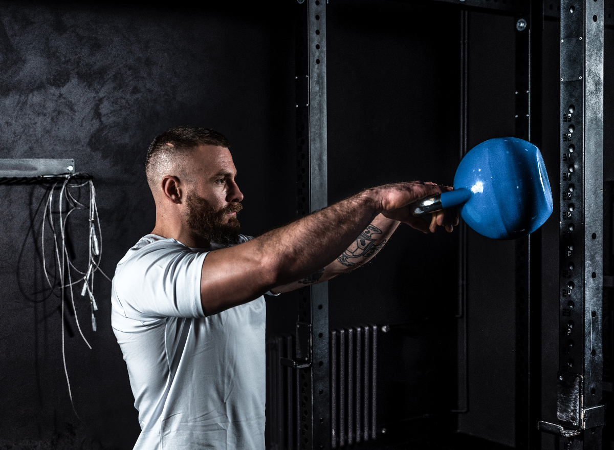 man doing kettlebell swings, concept of strength workout to melt hanging belly fat after 30