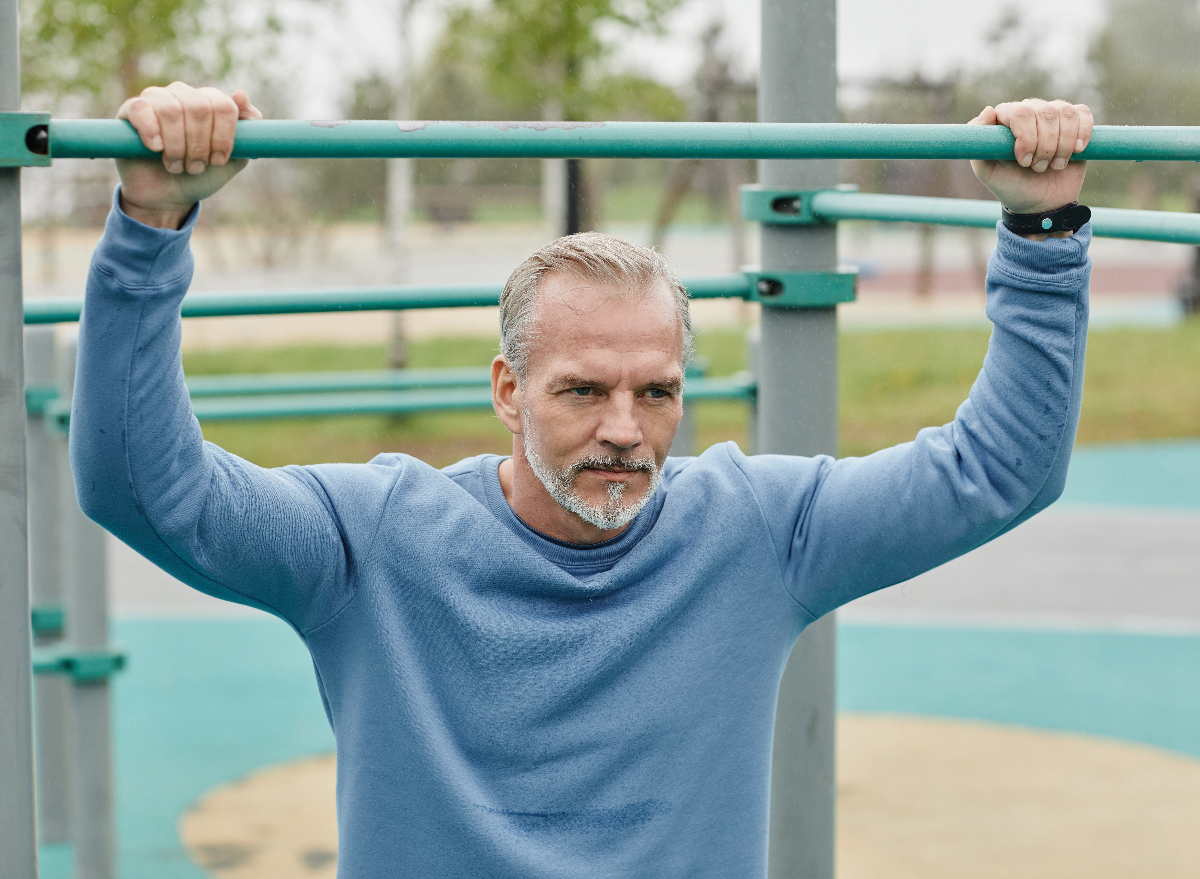 mature man doing pull-ups, concept of exercises for men over 50 to live longer