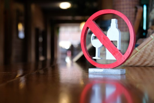 No alcohol sign is on a wooden table in the hostel