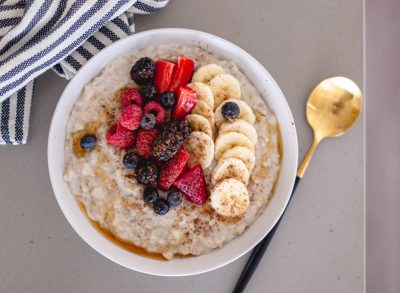 bowl of oatmeals with berries and fruit, concept of superfoods to boost energy and maximize workouts