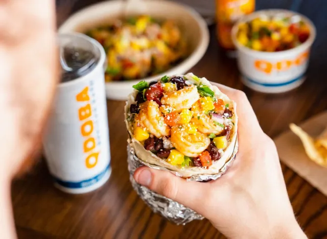 person holding qdoba's citrus lime burrito