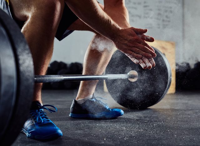 man getting ready to lift heavy dumbbell at the gym