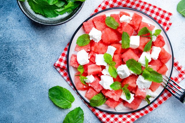 Refreshing summer juicy Watermelon salad with feta cheese and fresh mint, gray table