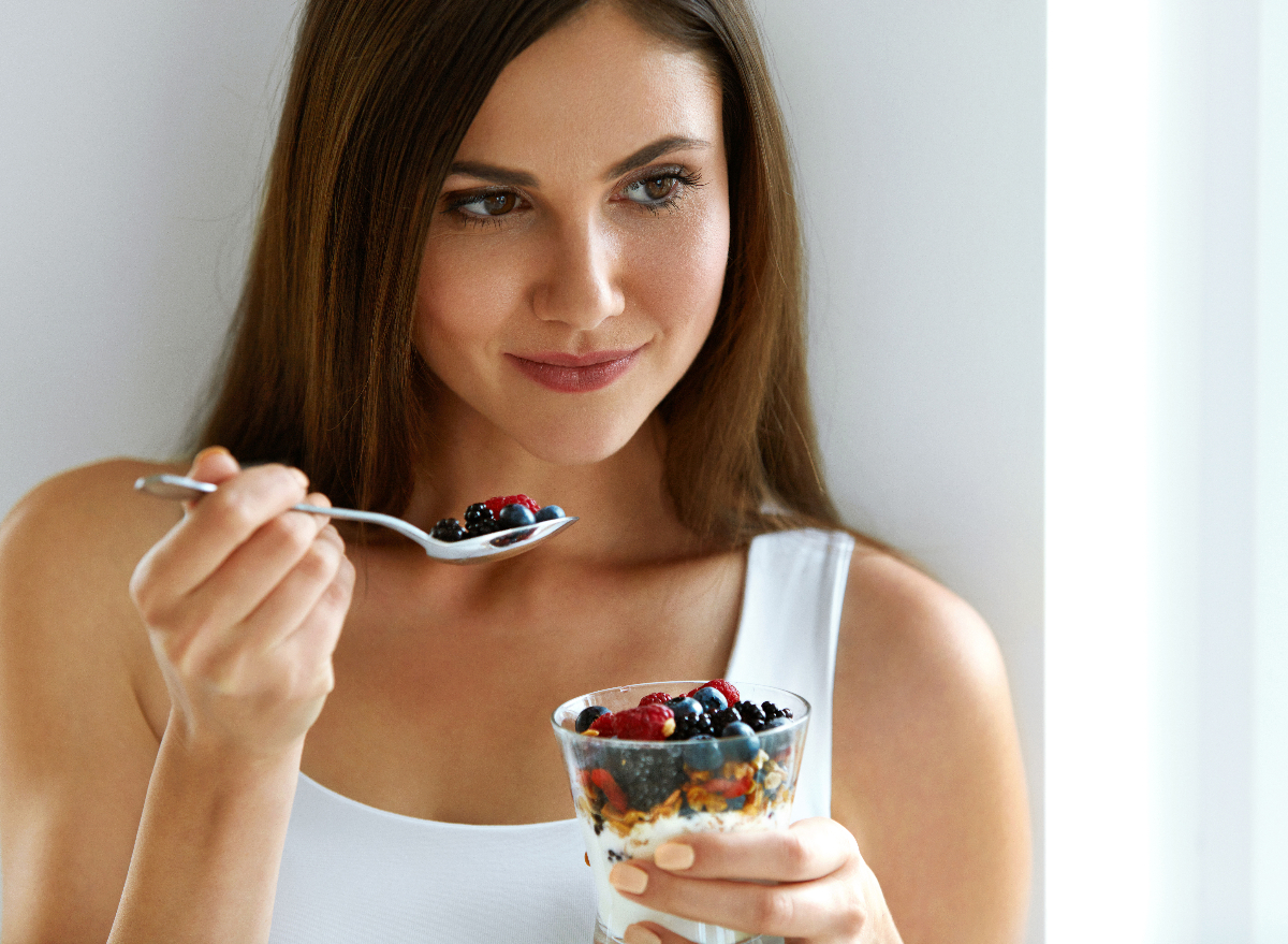 woman eating yogurt parfait, concept of eating habits to slim down your waist in 30 days