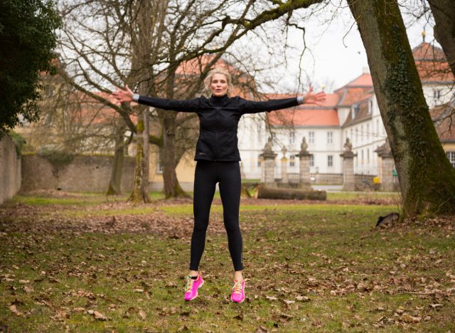 fitness woman doing jumping jacks outdoors