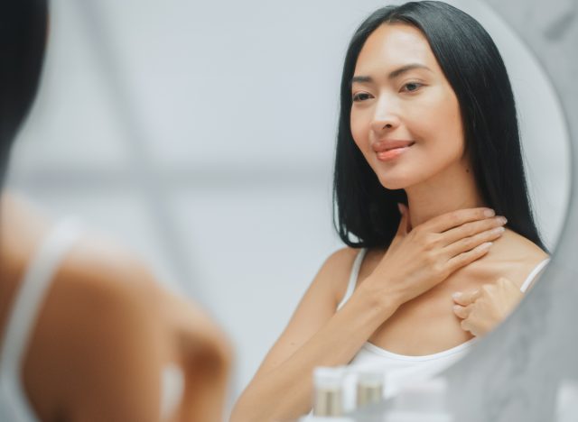 woman looking at neck skin, concept of ways to minimize neck wrinkles
