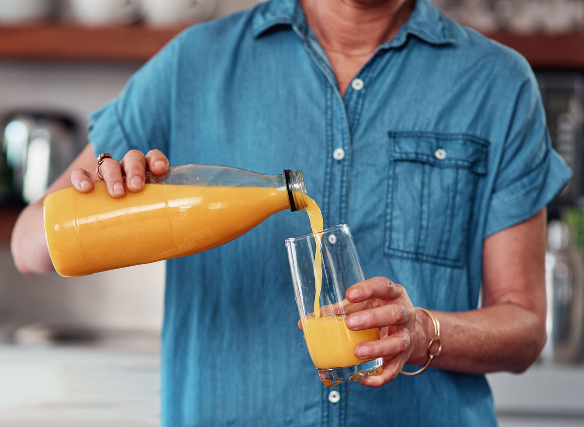 woman pouring juice from a bottle
