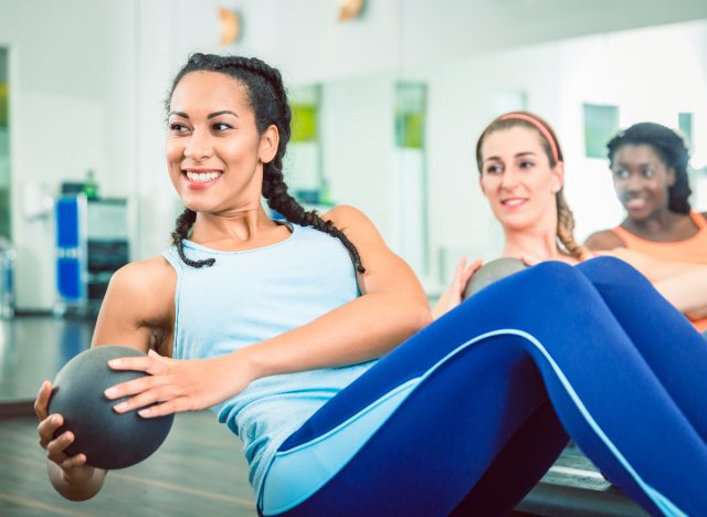 woman doing russian twists, concept of workout to lose love handles