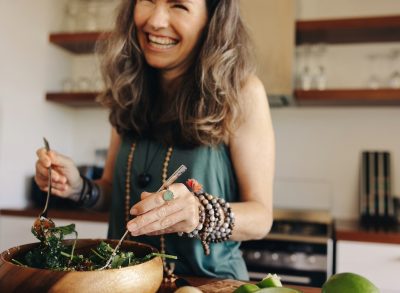 close-up woman making salad, concept of things that make losing weight easier after 50