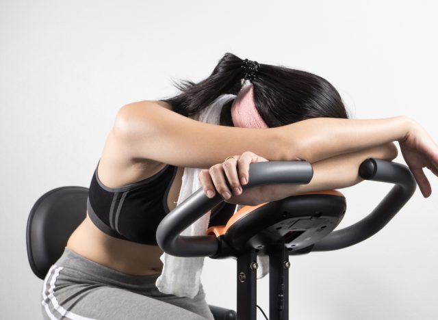 fitness woman on exercise bike exhausted