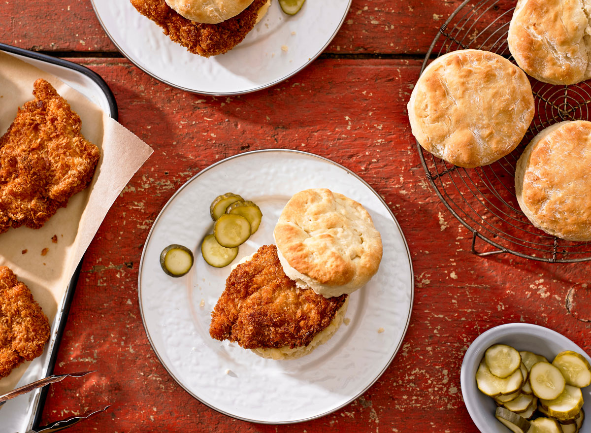 Cold Fried Chicken and Biscuits with pickles on red wood table