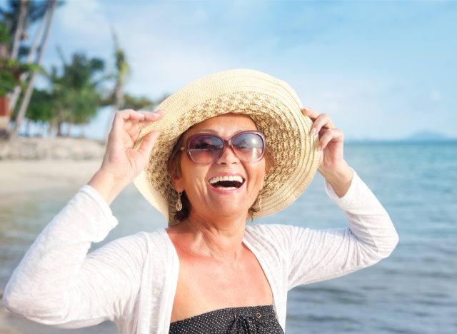 happy older woman smiling on beach