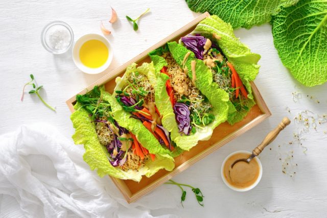 Vegan detox spring rolls with quinoa, sprouts and Thai peanut sauce, view from above, flat lay