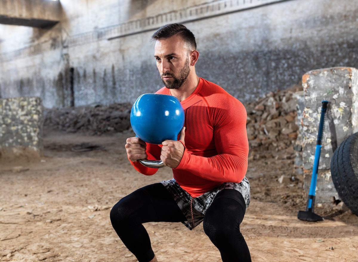 fit man doing kettlebell squats, concept of strength exercises to look and feel younger