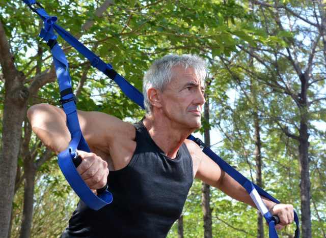 mature man using TRX straps, concept of fitness tips to prevent muscle loss for men
